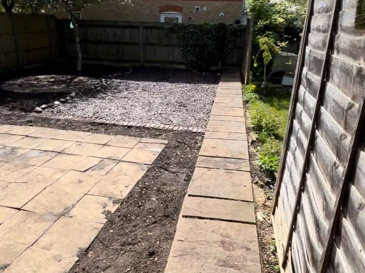 Bare ground either side of a newly laid path